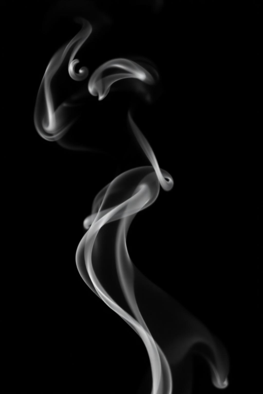 A single plume of white smoke rising against pitch black